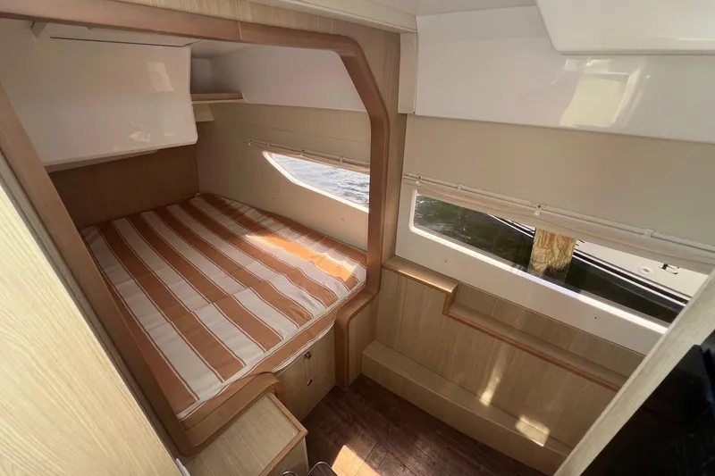 Slide: The Image of Cozy cabin interior of 2019 Aquila 36 Sport with striped bedding and wooden accents. - 29