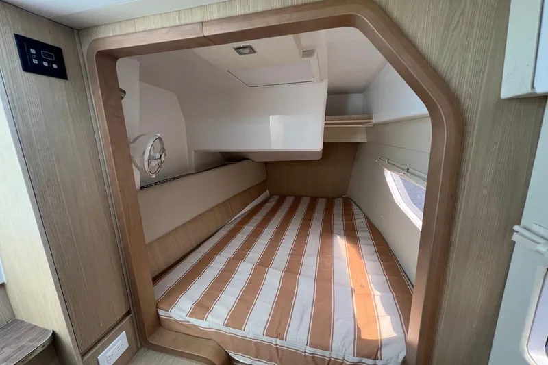 Slide: The Image of 2019 Aquila 36 Sport cabin interior with striped bedding and wooden accents. - 26