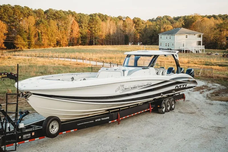 Slide: The Image of 2018 MTI 57 boat on trailer in rural setting with autumn trees and house. - 16