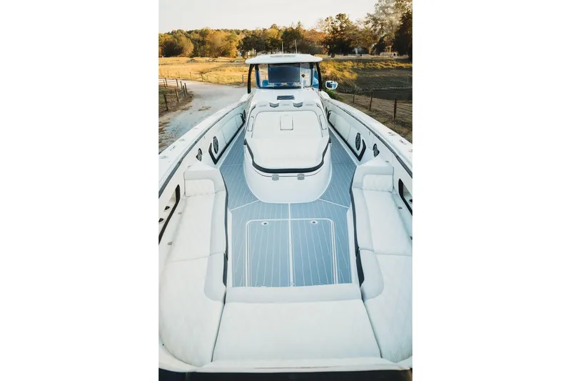 Slide: The Image of 2018 MTI 57 boat with spacious deck and luxurious seating in a scenic outdoor setting. - 61