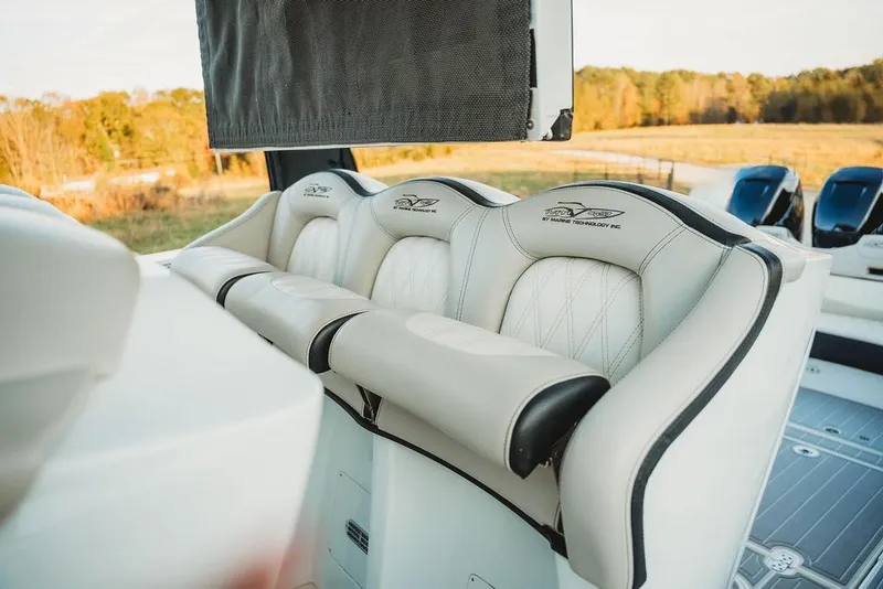 Slide: The Image of Luxurious seating on a 2018 MTI 57 boat with scenic countryside backdrop. - 31