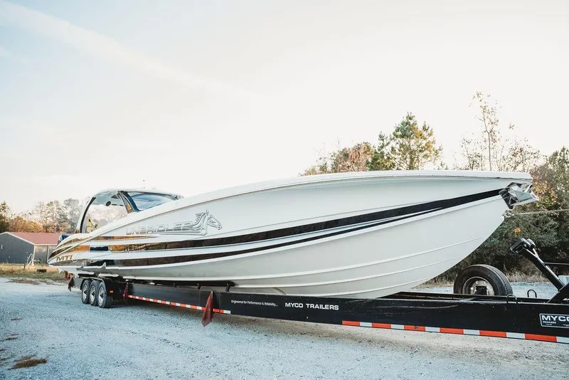 Slide: The Image of 2018 MTI 57 boat on trailer, parked outdoors, showcasing sleek design and performance features. - 4