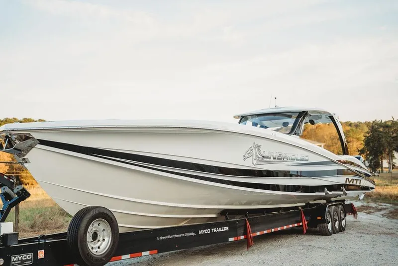 Slide: The Image of 2018 MTI 57 boat on trailer, sleek design, outdoors, side view. - 12