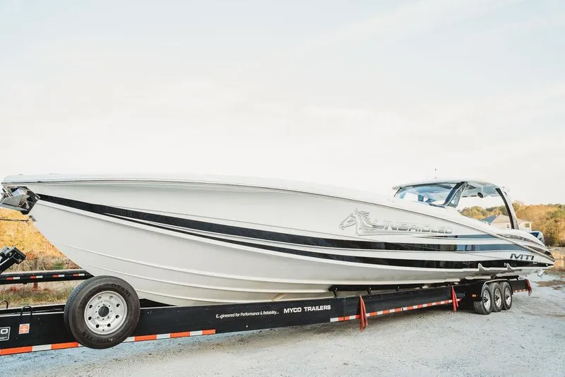 Slide: The Image of 2018 MTI 57 boat on trailer, sleek design, white with black accents. - 7
