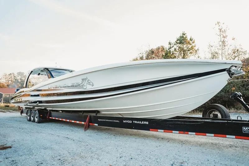 Slide: The Image of 2018 MTI 57 boat on trailer, sleek design, parked outdoors. - 5