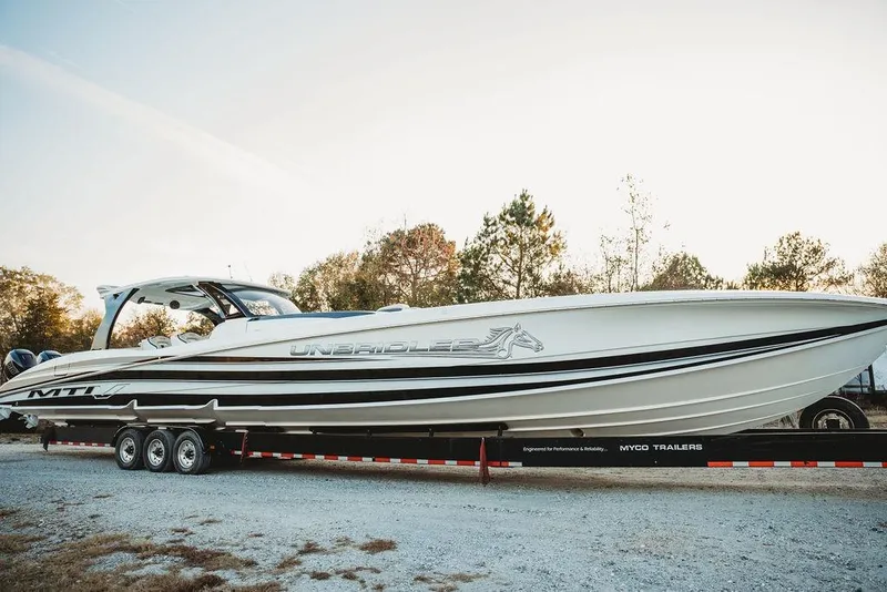 The Image of 2018 MTI 57 boat on trailer, sleek design, outdoors, side view. - 0