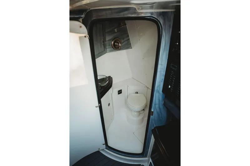 Slide: The Image of Compact bathroom inside 2018 MTI 57 boat, featuring a toilet and sink. - 49
