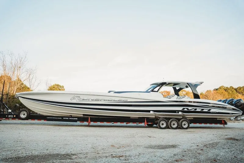 Slide: The Image of 2018 MTI 57 powerboat on trailer, sleek design, parked outdoors. - 6