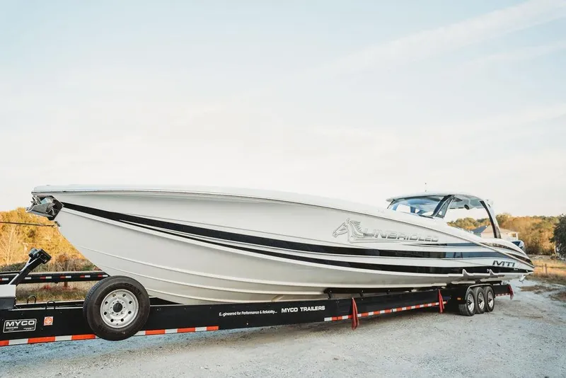Slide: The Image of 2018 MTI 57 boat on trailer, sleek design, outdoors. - 9