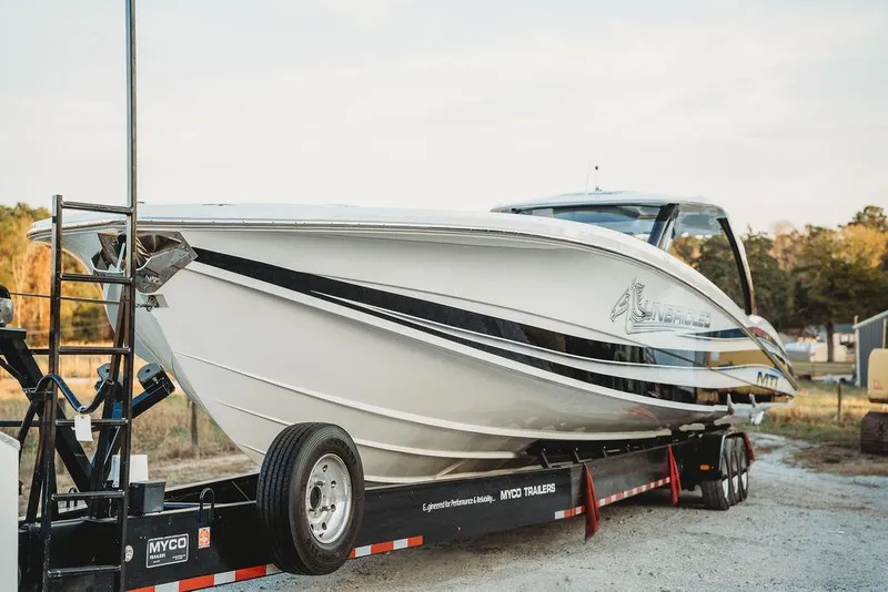 Slide: The Image of 2018 MTI 57 boat on trailer, sleek design, parked outdoors. - 11