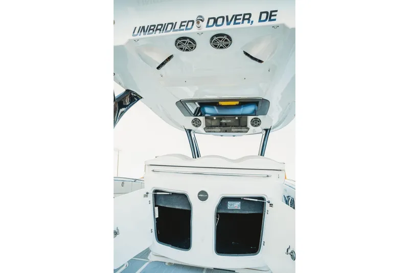 Slide: The Image of 2018 MTI 57 boat interior with storage and audio system, labeled "Unbridled, Dover, DE". - 38