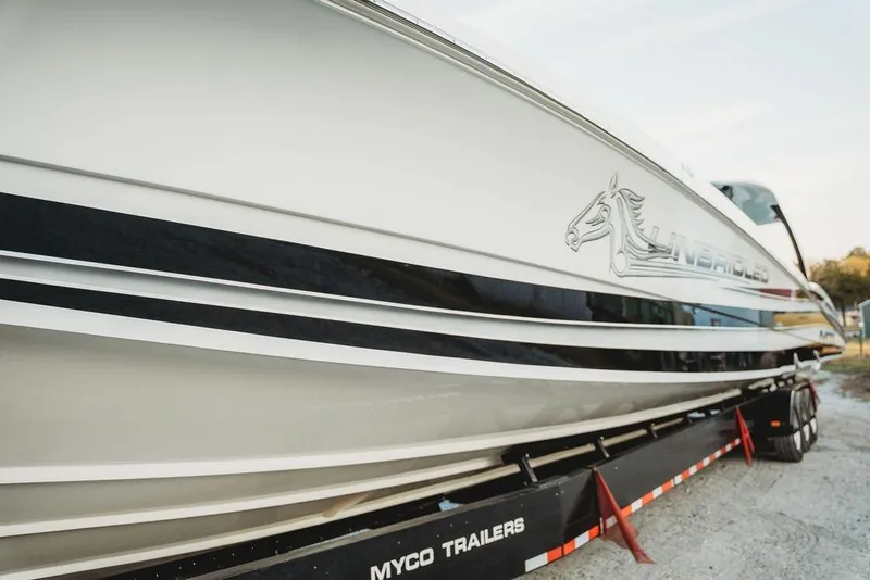 Slide: The Image of 2018 MTI 57 boat on Myco trailer, featuring sleek design and horse logo. - 10