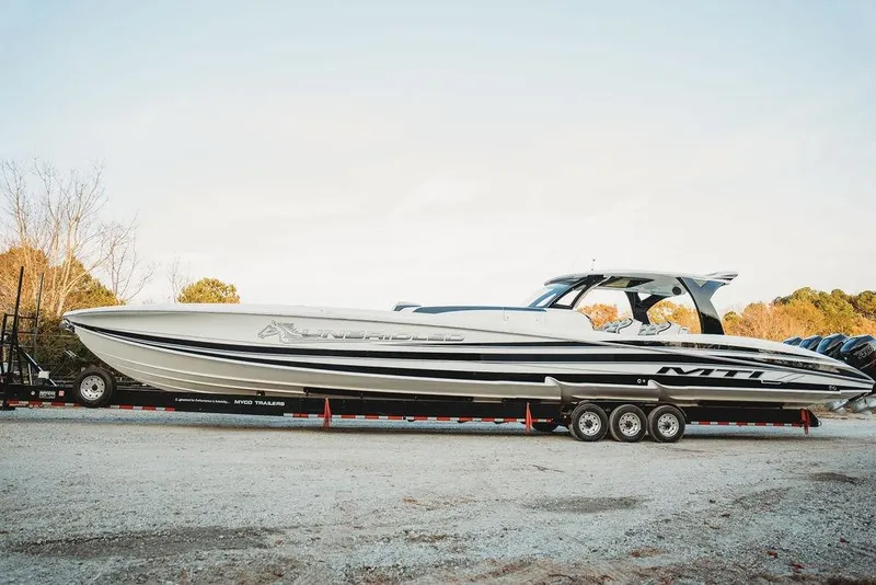 Slide: The Image of 2018 MTI 57 boat on trailer, sleek design, parked outdoors. - 13