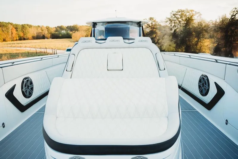 Slide: The Image of Luxurious 2018 MTI 57 yacht interior with plush white seating and scenic background. - 64