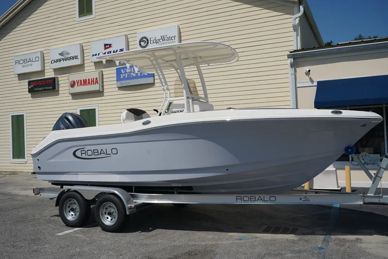 The Image of 2026 Robalo R202 Explorer boat on trailer outside dealership. - 1