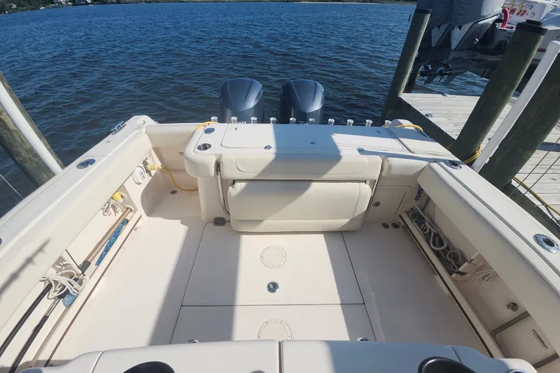 Slide: The Image of 2021 Grady-White Canyon 306 boat interior with twin engines at dock. - 17