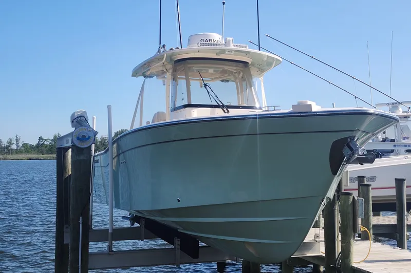 Slide: The Image of 2021 Grady-White Canyon 306 boat docked on a lift by the water. - 3