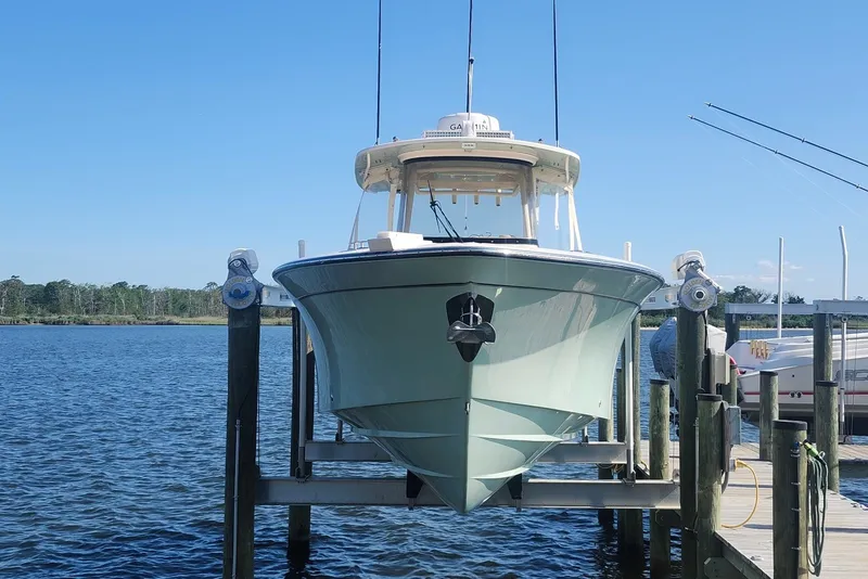 Slide: The Image of 2021 Grady-White Canyon 306 boat docked on a lift by the water. - 5