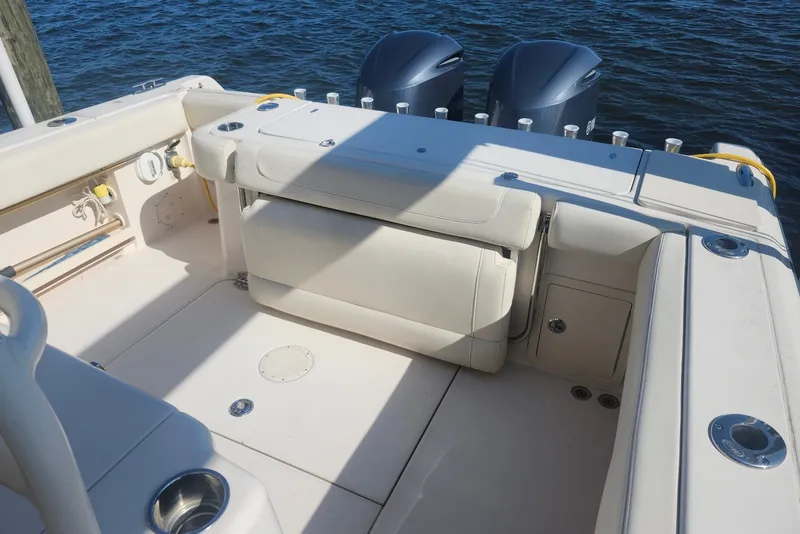 Slide: The Image of 2021 Grady-White Canyon 306 boat interior with dual engines, featuring spacious seating and storage. - 18
