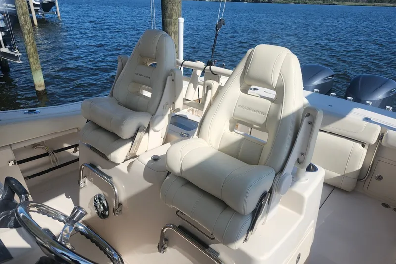 Slide: The Image of 2021 Grady-White Canyon 306 boat interior with luxurious seating and ocean backdrop. - 10