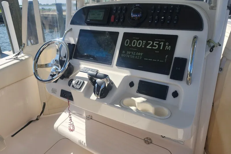 Slide: The Image of 2021 Grady-White Canyon 306 boat dashboard with GPS and navigation controls. - 14