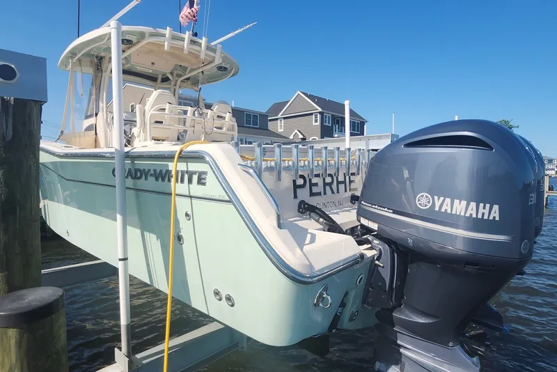 Slide: The Image of 2021 Grady-White Canyon 306 boat with Yamaha engine docked by waterfront homes. - 8