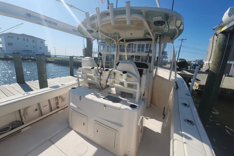 Slide: The Image of 2021 Grady-White Canyon 306 boat docked at a marina under clear blue skies. - 16