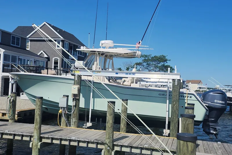 Slide: The Image of 2021 Grady-White Canyon 306 boat docked with Yamaha engines, near waterfront homes. - 7