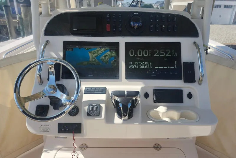 Slide: The Image of 2021 Grady-White Canyon 306 helm with navigation screens and steering wheel. - 12