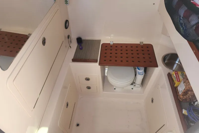 Slide: The Image of 2021 Grady-White Canyon 306 boat interior with compact bathroom and storage features. - 28