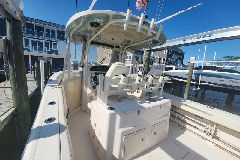 Slide: The Image of 2021 Grady-White Canyon 306 boat docked at marina under clear blue sky. - 15