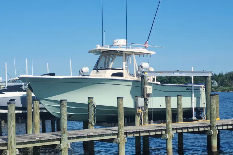 The Image of 2021 Grady-White Canyon 306 boat docked at a marina under clear blue skies. - 0