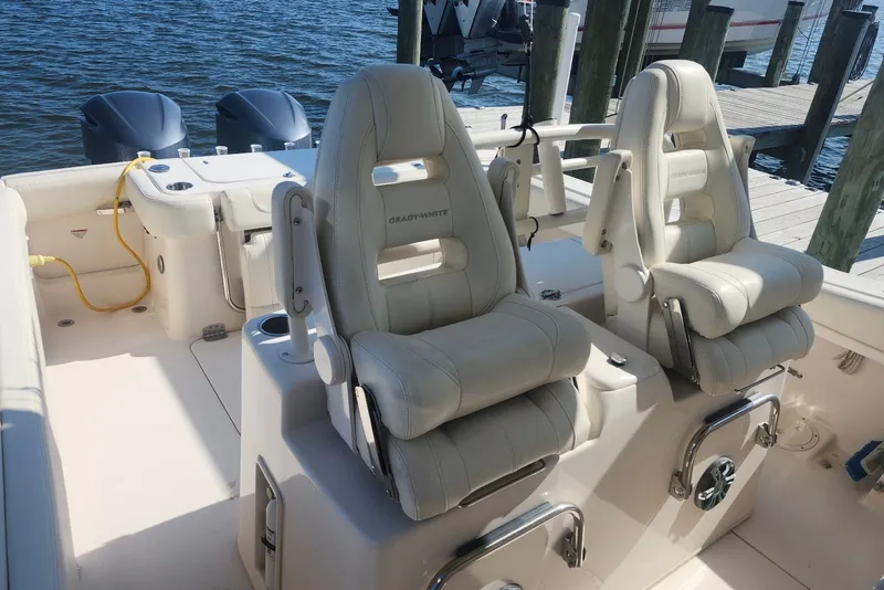 Slide: The Image of 2021 Grady-White Canyon 306 boat interior with dual seats and twin engines at dock. - 11