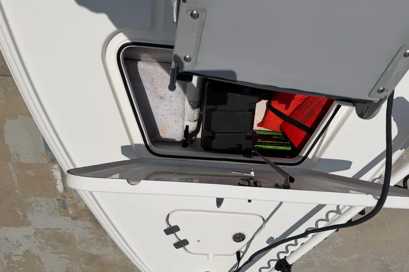 Slide: The Image of Open storage compartment on 2018 Bomb Island 160 Side Console boat, showing interior equipment. - 17