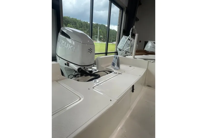 Slide: The Image of 2026 Bulls Bay 2400 boat with Suzuki outboard motor, displayed indoors. - 8