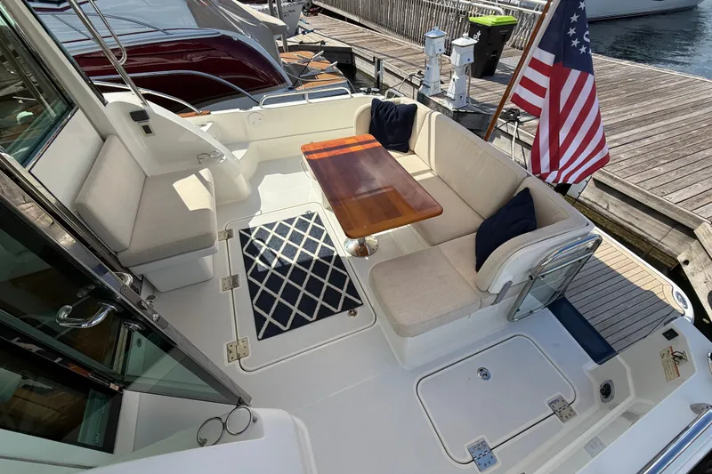 Slide: The Image of 2018 Sabre 45 Salon Express yacht deck with seating, table, and American flag. - 28