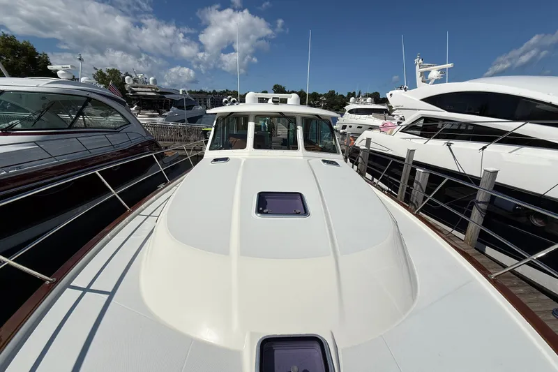 Slide: The Image of 2018 Sabre 45 Salon Express yacht docked among other luxury boats under a clear blue sky. - 15