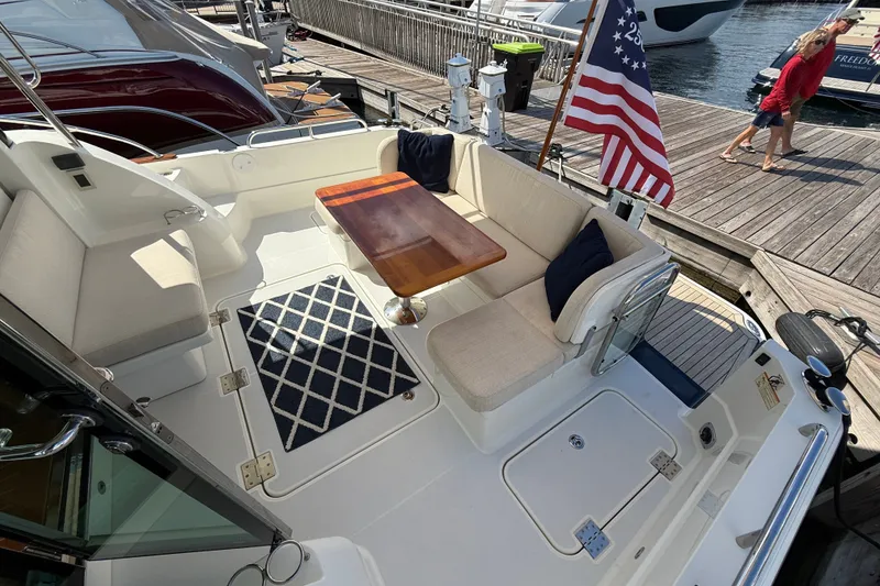 Slide: The Image of 2018 Sabre 45 Salon Express yacht deck with seating, table, and American flag. - 27