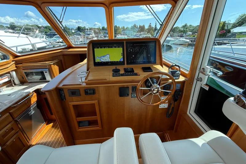 Slide: The Image of Helm of 2018 Sabre 45 Salon Express yacht with navigation screens and wooden interior. - 42