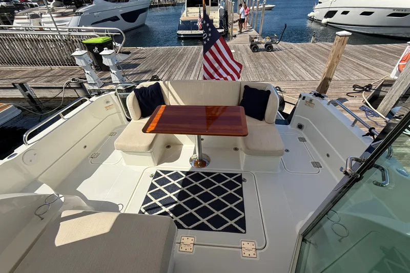 Slide: The Image of 2018 Sabre 45 Salon Express yacht deck with seating, table, and American flag. - 26