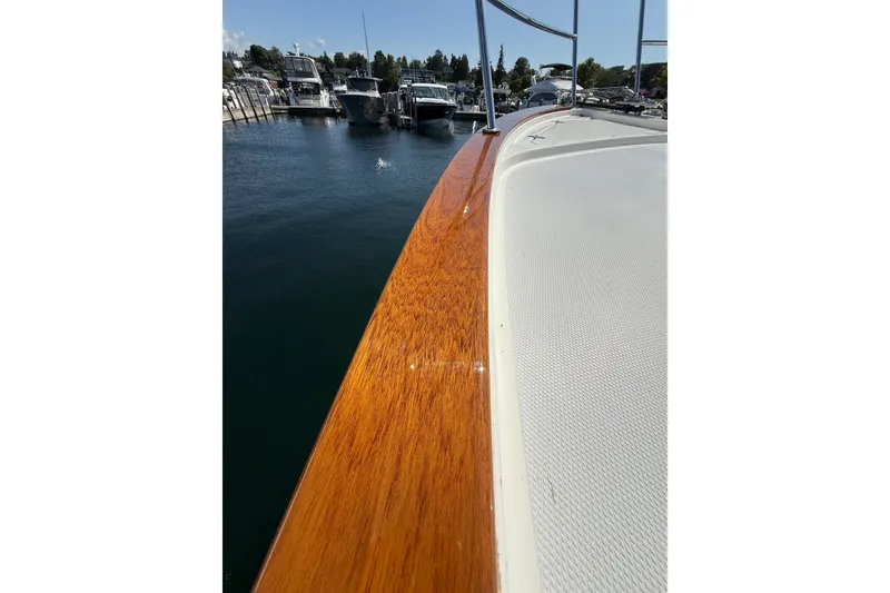 Slide: The Image of 2018 Sabre 45 Salon Express yacht with polished wood railing, docked in marina. - 29