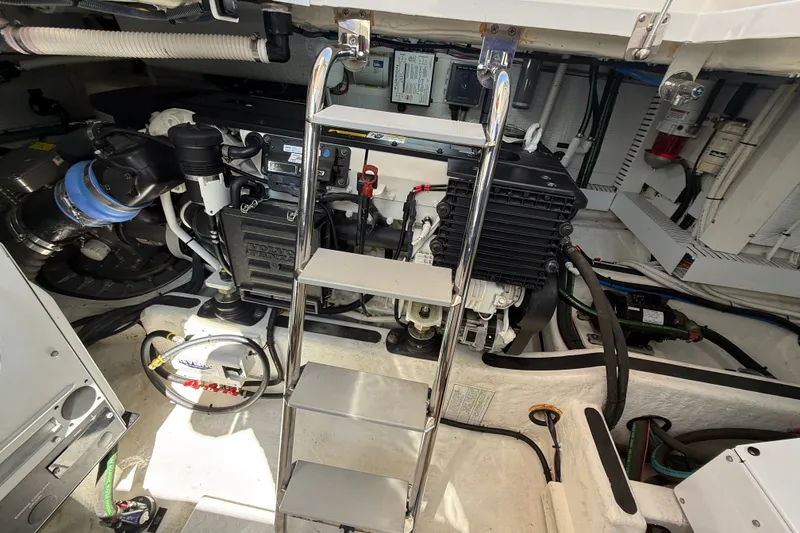 Slide: The Image of Engine room of a 2018 Sabre 45 Salon Express yacht, featuring mechanical components and a ladder. - 75