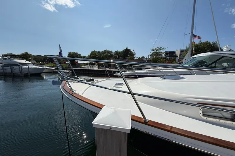 Slide: The Image of 2018 Sabre 45 Salon Express yacht docked in a marina under clear blue skies. - 13