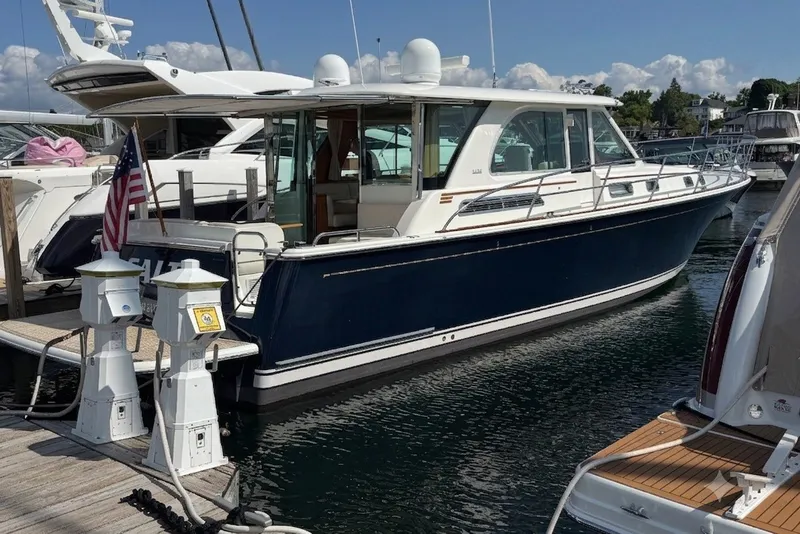 Slide: The Image of 2018 Sabre 45 Salon Express yacht docked at marina, featuring sleek design and American flag. - 8
