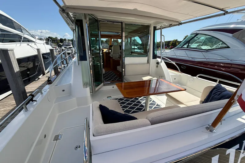 Slide: The Image of 2018 Sabre 45 Salon Express yacht with elegant outdoor seating and polished wood table. - 22