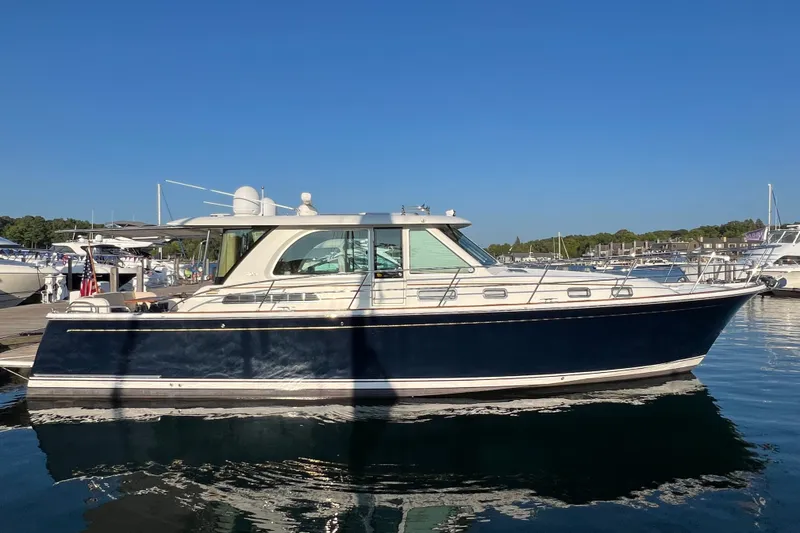 Slide: The Image of 2018 Sabre 45 Salon Express yacht docked in a marina under clear blue skies. - 1