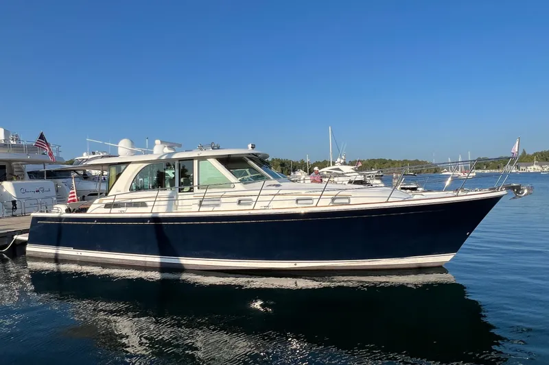 Slide: The Image of 2018 Sabre 45 Salon Express yacht docked in a serene marina setting. - 2