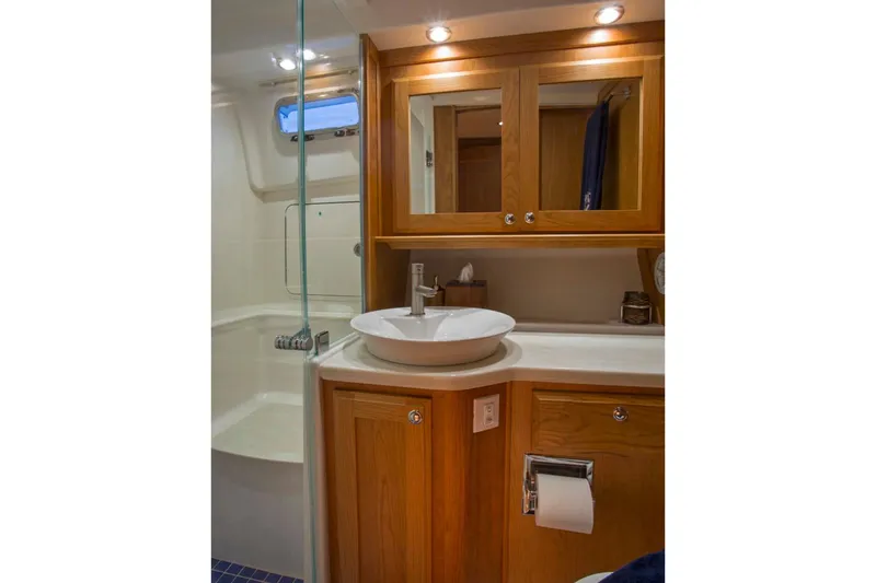 Slide: The Image of Manufacturer Provided Image: 2019 Sabre 45 Salon Express bathroom with wooden cabinetry and modern fixtures. - 59