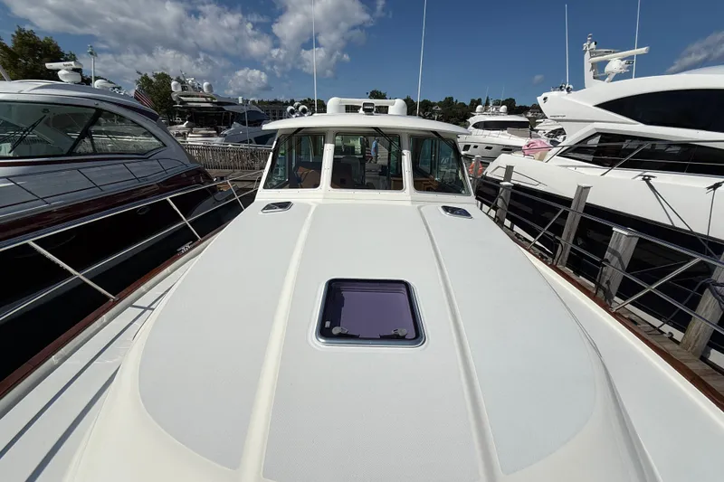Slide: The Image of 2018 Sabre 45 Salon Express yacht docked among other luxury boats under a blue sky. - 16
