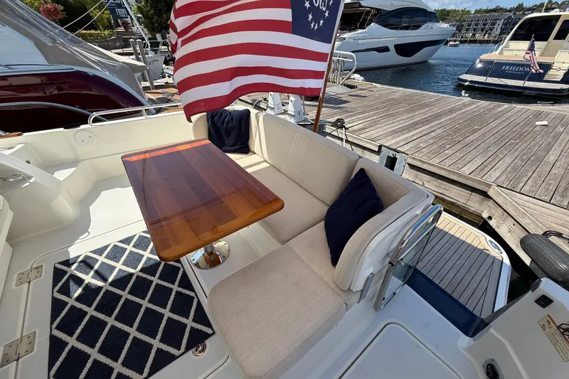 Slide: The Image of 2018 Sabre 45 Salon Express yacht with American flag, docked, featuring elegant seating and table. - 24